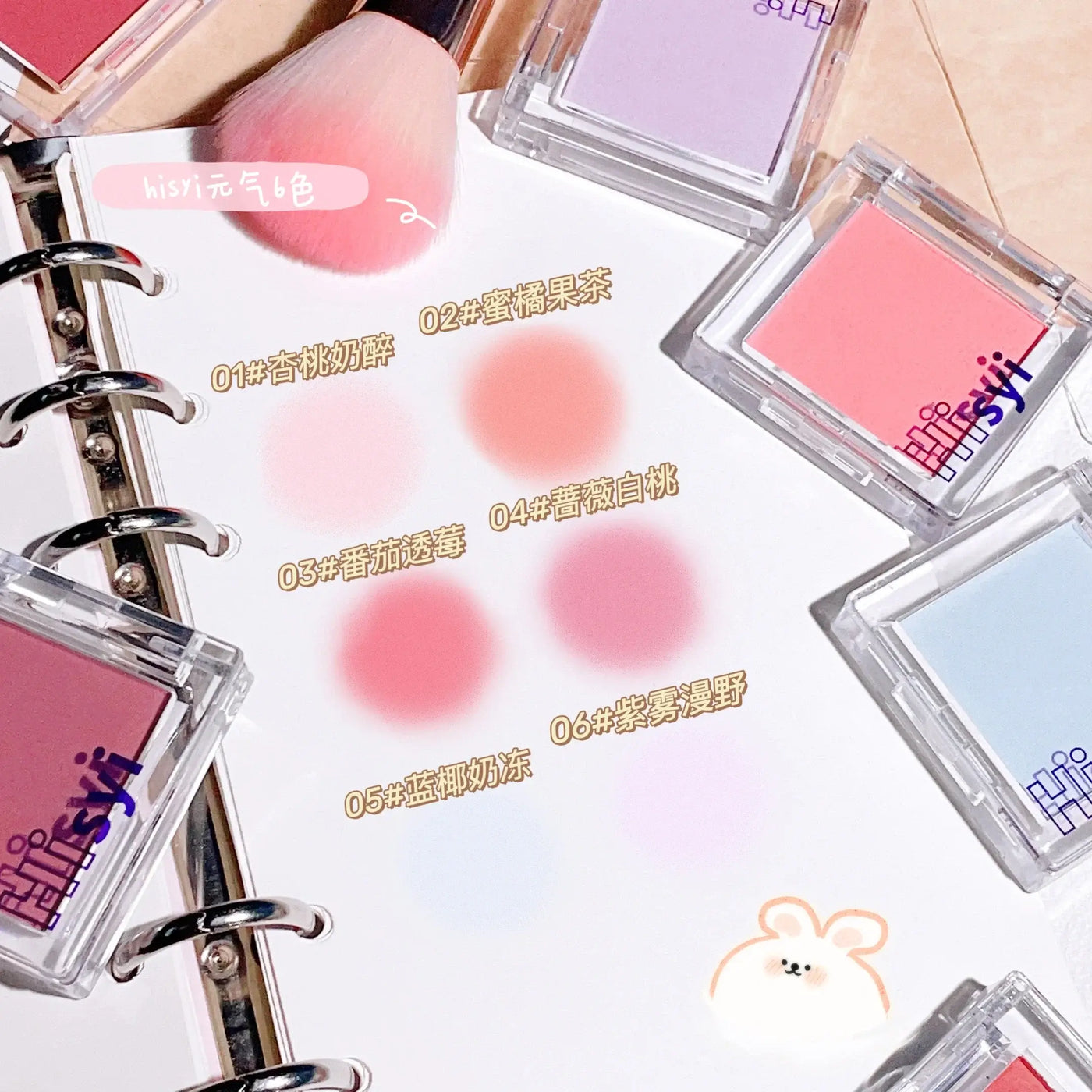 Frost Glow Cosmetics brightening blush in pink tone with applicator and swatch, ideal for a youthful glow.