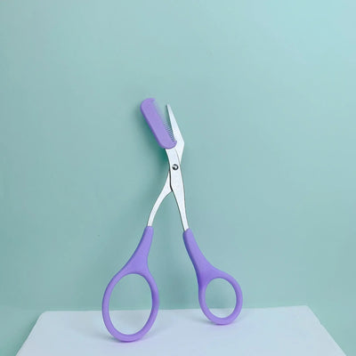 Frost Glow Cosmetics pink eyebrow scissors with built-in comb. Stainless steel, precise grooming tool for shaping perfect brows.