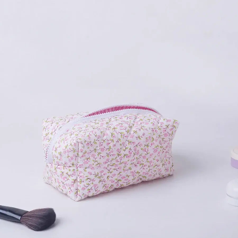 Spacious floral quilted makeup bag with soft puffy design. Perfect for travel or daily use to keep cosmetics organized. Shop Frost Glow Cosmetics today!