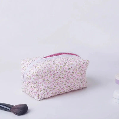 Spacious floral quilted makeup bag with soft puffy design. Perfect for travel or daily use to keep cosmetics organized. Shop Frost Glow Cosmetics today!
