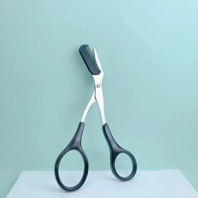 Frost Glow Cosmetics pink eyebrow scissors with built-in comb. Stainless steel, precise grooming tool for shaping perfect brows.