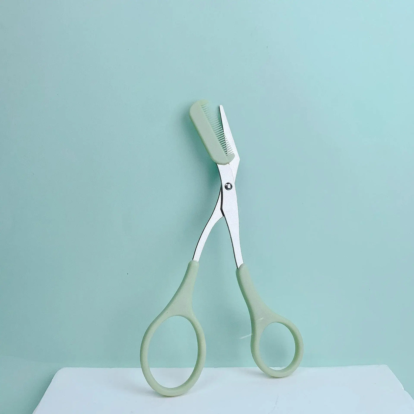 Frost Glow Cosmetics pink eyebrow scissors with built-in comb. Stainless steel, precise grooming tool for shaping perfect brows.34w2w