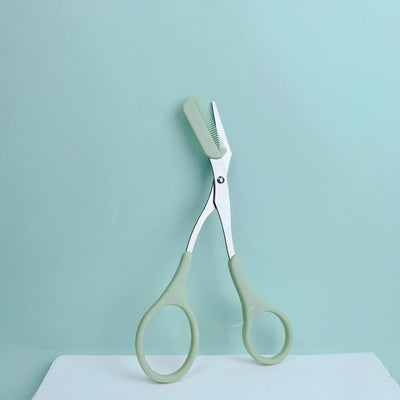 Frost Glow Cosmetics pink eyebrow scissors with built-in comb. Stainless steel, precise grooming tool for shaping perfect brows.34w2w