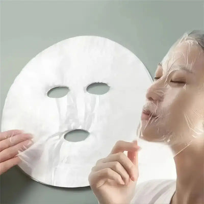 Frost Glow Cosmetics 100pcs facial mask paper sheets are unscented, hydrating & moisture-retentive DIY skincare wraps for soft skin.