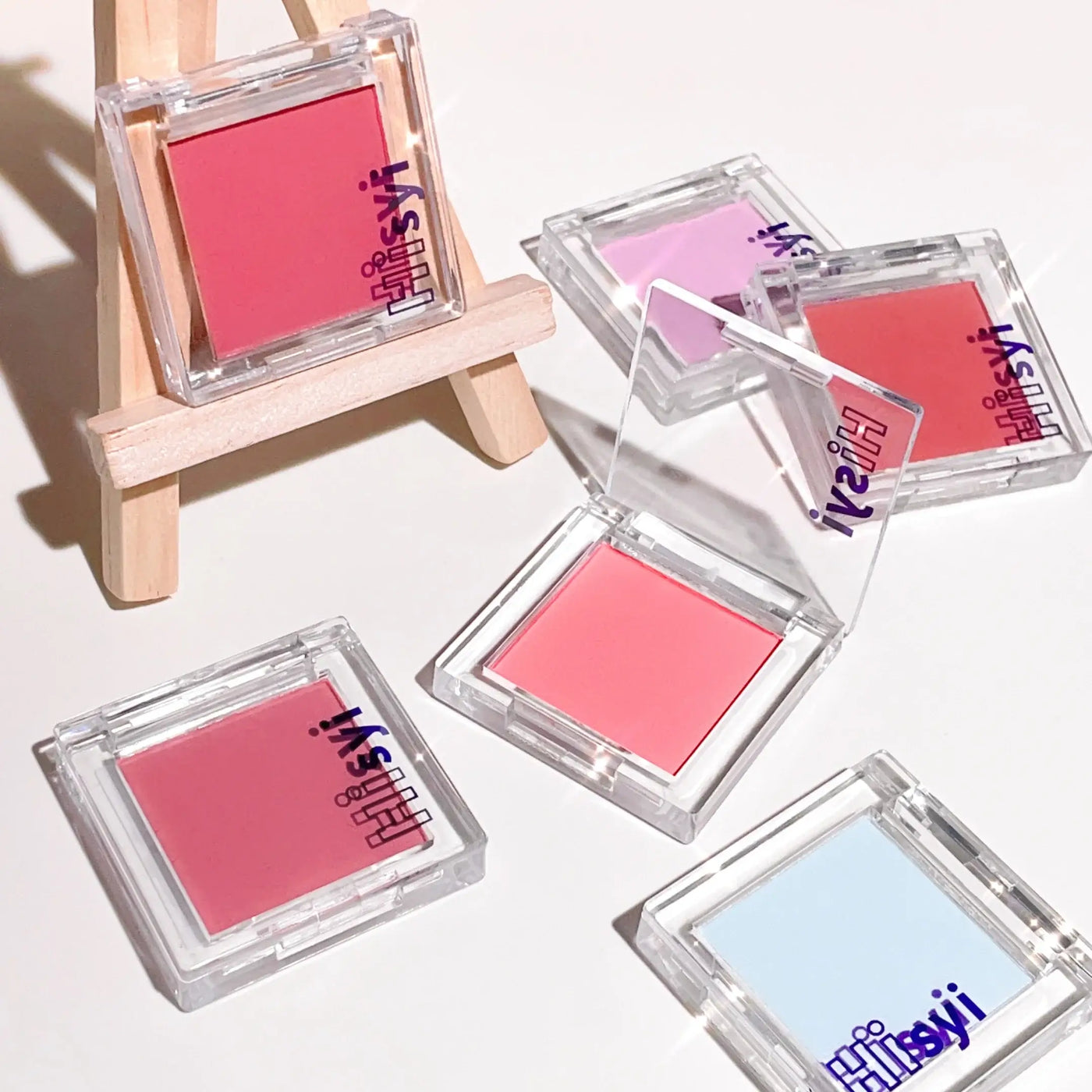Frost Glow Cosmetics brightening blush in pink tone with applicator and swatch, ideal for a youthful glow.