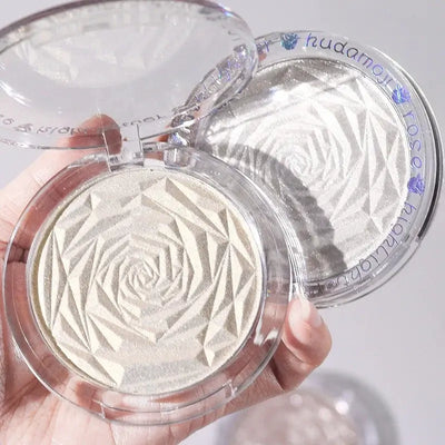 Frost Glow Cosmetics Diamond Glow highlighter showcased on skin and model, featuring shimmering rose-patterned design.