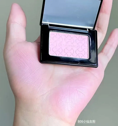 Model showcasing Blooming Blush Powder in B07, featuring soft pink tones and long-lasting cheek tint effect.