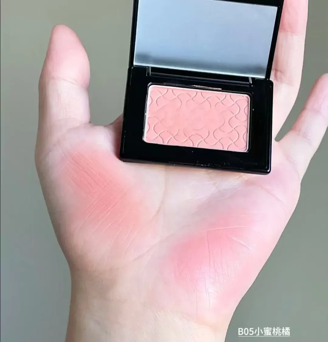 Model showcasing Blooming Blush Powder in B07, featuring soft pink tones and long-lasting cheek tint effect.