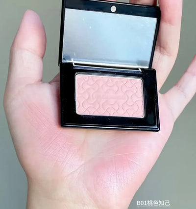 Model showcasing Blooming Blush Powder in B07, featuring soft pink tones and long-lasting cheek tint effect.