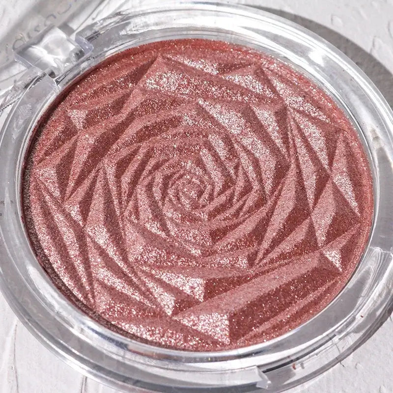 Frost Glow Cosmetics Diamond Glow highlighter showcased on skin and model, featuring shimmering rose-patterned design.