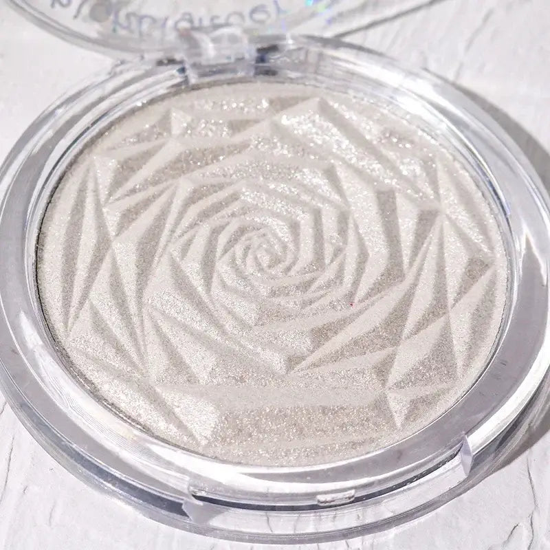 Frost Glow Cosmetics Diamond Glow highlighter showcased on skin and model, featuring shimmering rose-patterned design.