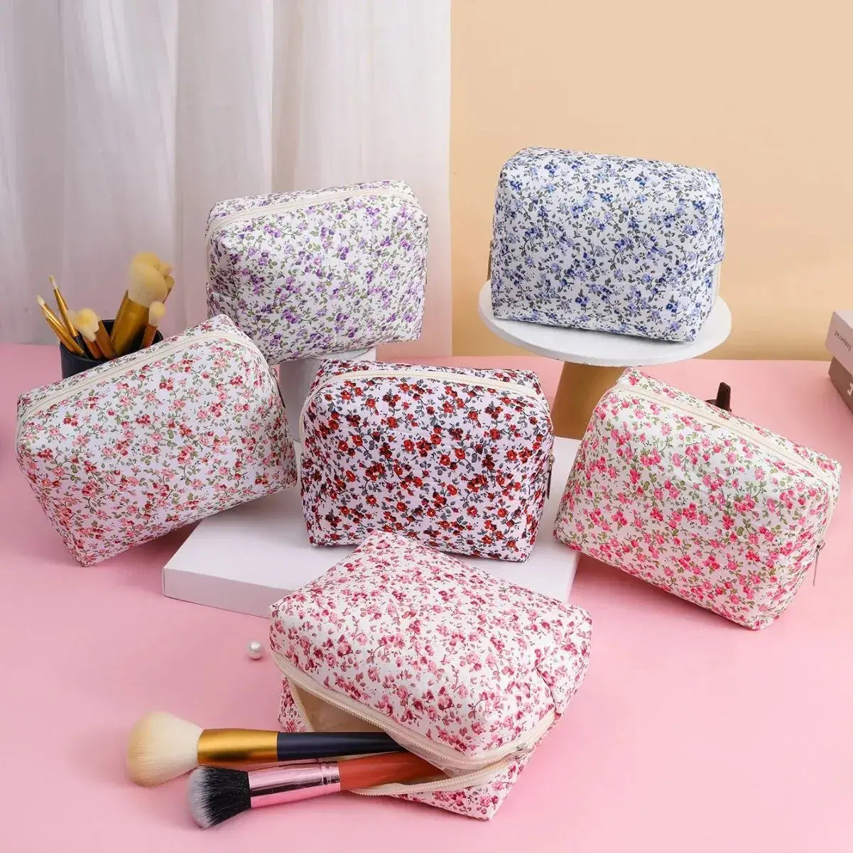 Spacious floral quilted makeup bag for travel & daily use. Puffy, stylish & durable design keeps cosmetics organized. Shop Frost Glow Cosmetics today!