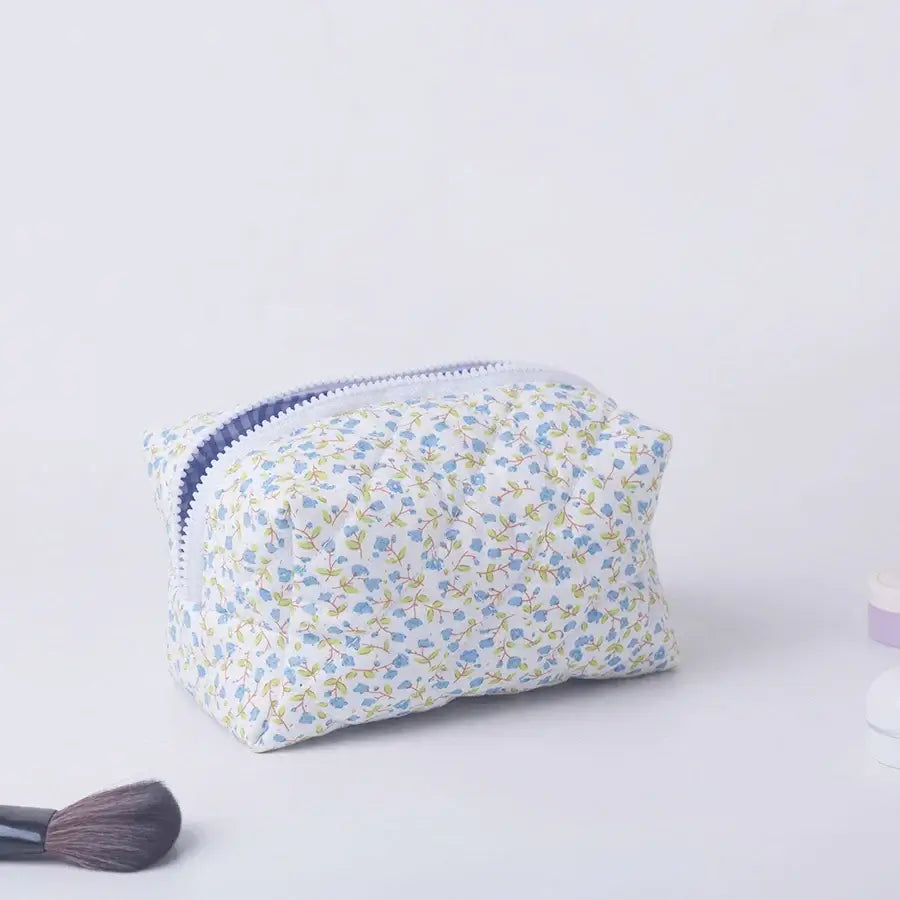 Spacious floral quilted makeup bag with soft puffy design. Perfect for travel or daily use to keep cosmetics organized. Shop Frost Glow Cosmetics today!