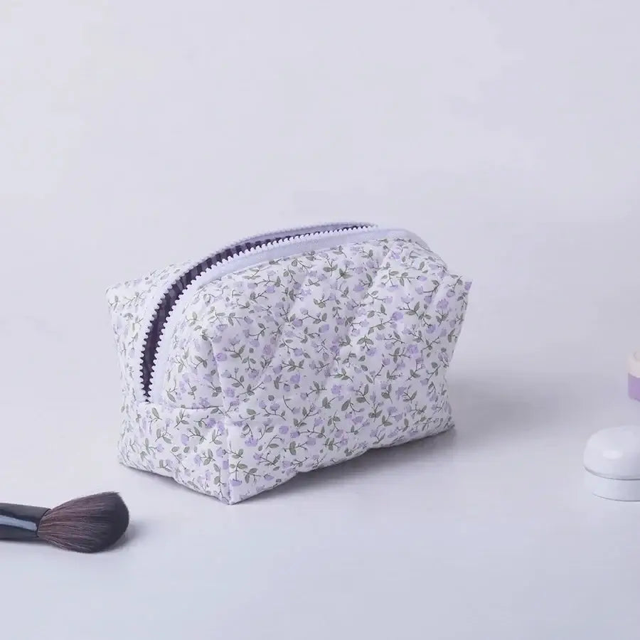 Spacious floral quilted makeup bag with soft puffy design. Perfect for travel or daily use to keep cosmetics organized. Shop Frost Glow Cosmetics today!