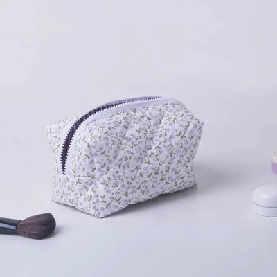 Spacious floral quilted makeup bag with soft puffy design. Perfect for travel or daily use to keep cosmetics organized. Shop Frost Glow Cosmetics today!